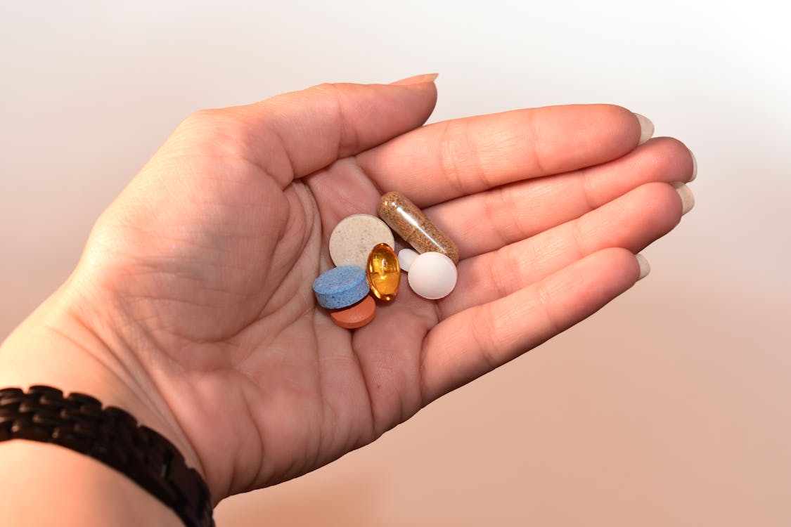 Free Person Holding Medication Pill and Capsules Stock Photo